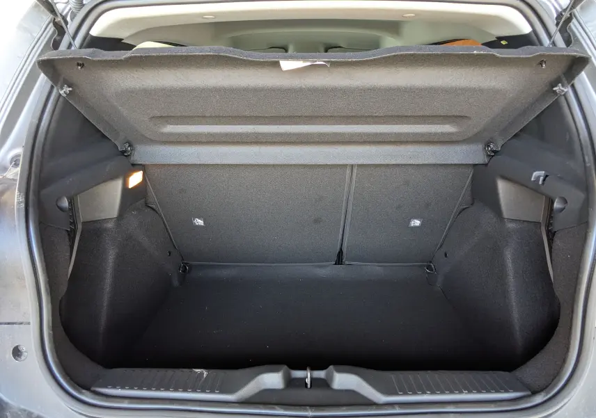 Coffre ouvert de la Citroën E-C3 113 MAX gris Mercury, vue arrière montrant l’espace de rangement vide et l’éclairage intérieur.