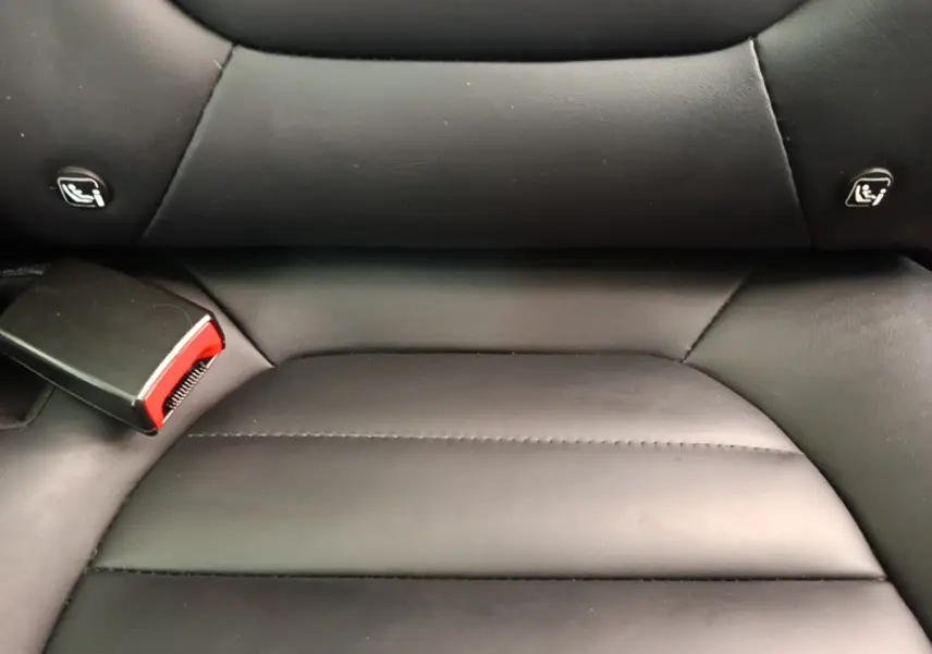 Gros plan sur la banquette arrière en cuir noir du MG MOTOR EHS 1.5T PHEV, avec attaches Isofix visibles.