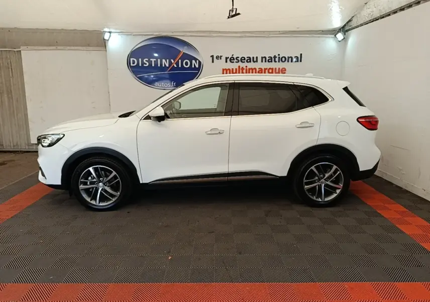 Vue de profil côté gauche du SUV blanc MG EHS 1.5T GDI PHEV Luxury 2023 dans un showroom intérieur.
