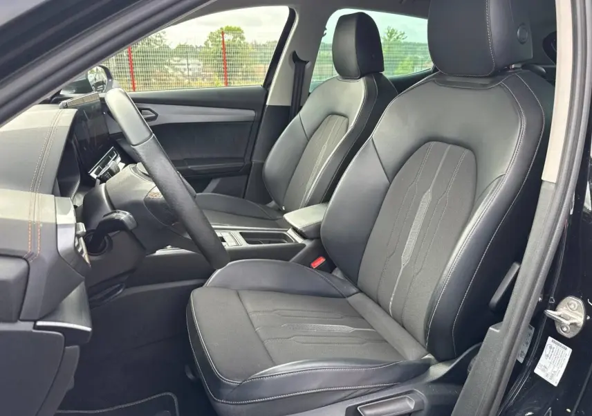 Vue intérieure côté conducteur du CUPRA Formentor 2.0 TDI 150ch 2023, sièges sport en tissu et similicuir noir avec surpiqûres cuivre.