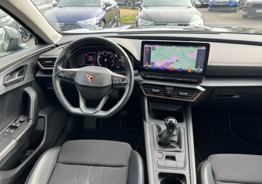Vue intérieure avant du CUPRA Formentor 2.0 TDI 150ch avec volant sport, écran tactile et levier de vitesse manuel noir.