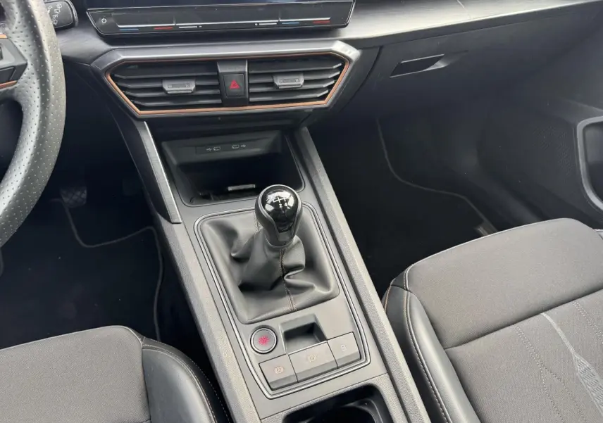 Vue rapprochée de la console centrale du CUPRA Formentor noir, mettant en valeur le levier de vitesse manuel et les sièges sport noirs.