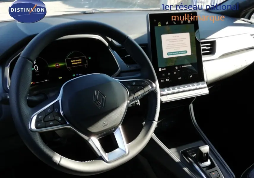 Intérieur du Renault Captur E-Tech 2026 vu du poste de conduite, volant cuir et écran tactile vertical.