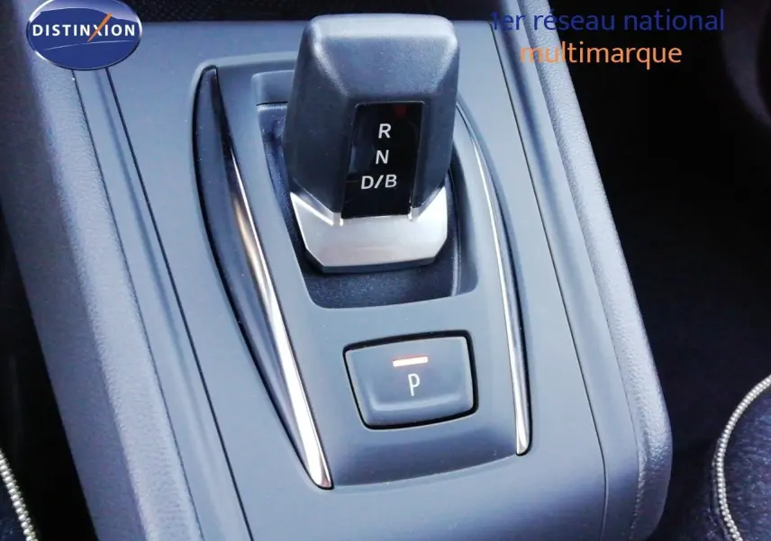 Gros plan sur la commande de boîte automatique du Renault Captur E-Tech hybride, avec bouton de stationnement éclairé.