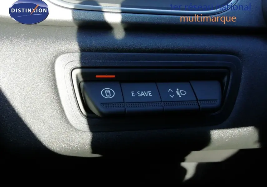 Gros plan sur les boutons de commande E-SAVE et réglage des phares du tableau de bord du Renault Captur blanc nacré 2026.