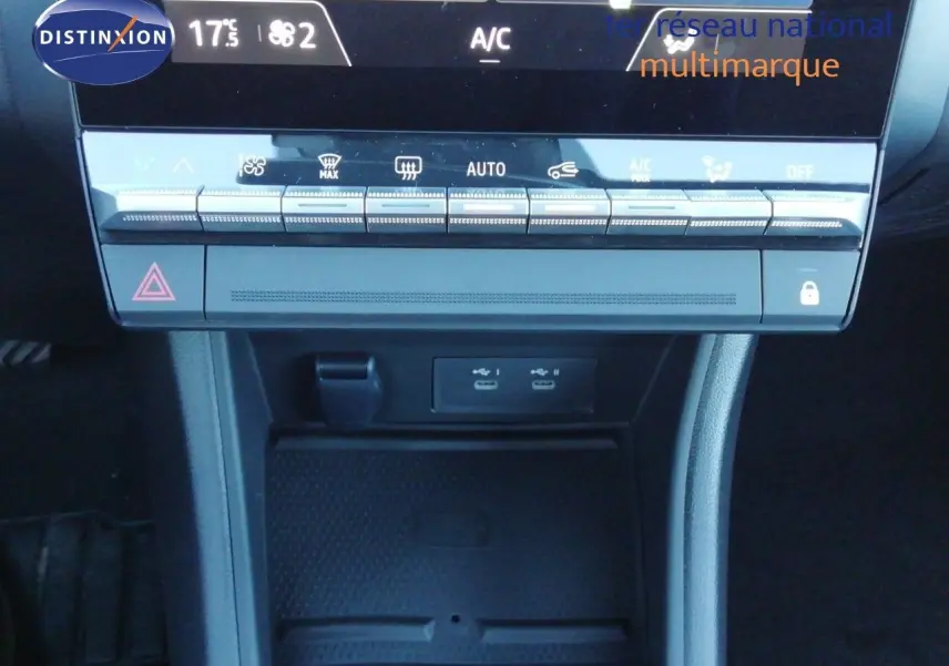 Vue rapprochée de la console centrale du Renault Captur blanc nacré avec toit noir, montrant les commandes climatisation et ports USB.