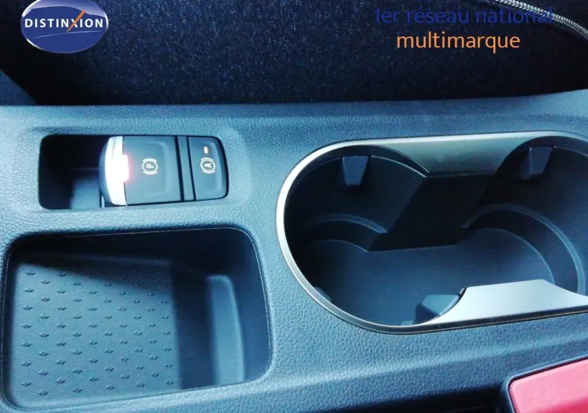 Gros plan sur la console centrale du Renault Captur 2026, montrant les porte-gobelets et les boutons de frein à main électrique.
