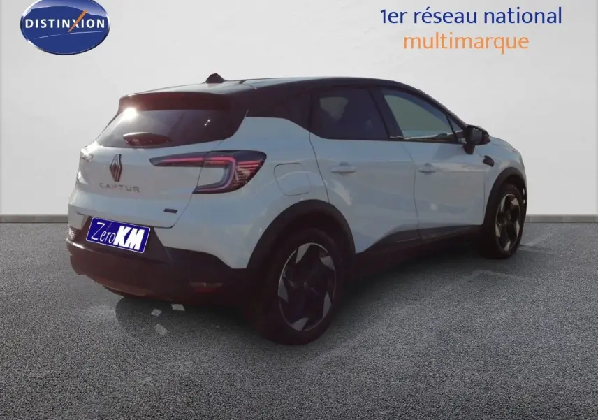Vue 3/4 arrière droite du Renault Captur blanc nacré avec toit noir, soulignant ses jantes et lignes modernes.