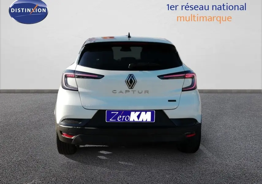 Vue arrière d’un Renault Captur blanc nacré avec toit noir, feux LED et logo central bien visibles.