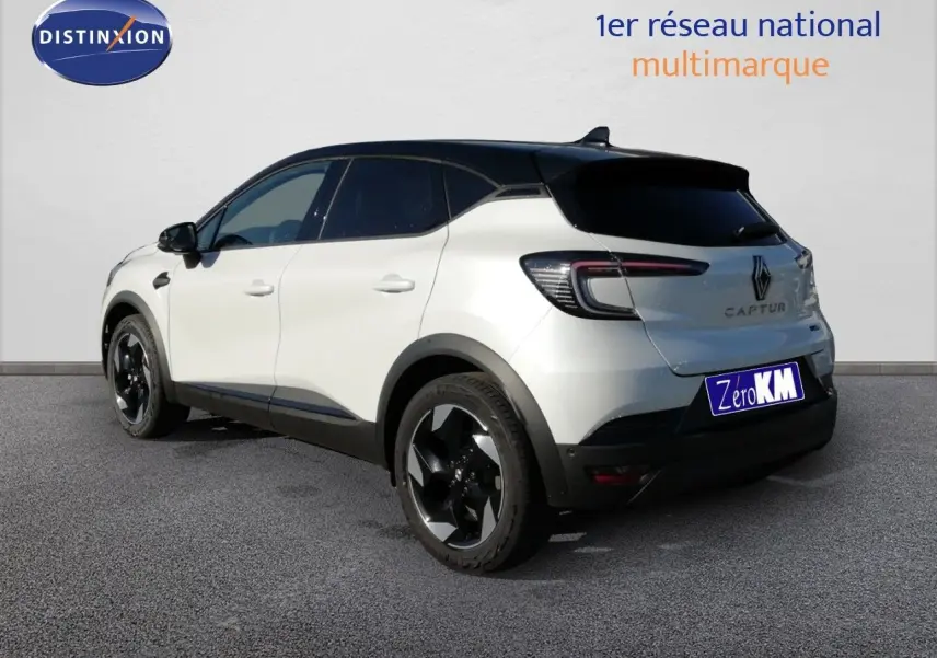 Vue 3/4 arrière droite du Renault Captur blanc nacré avec toit noir et jantes noires brillantes.