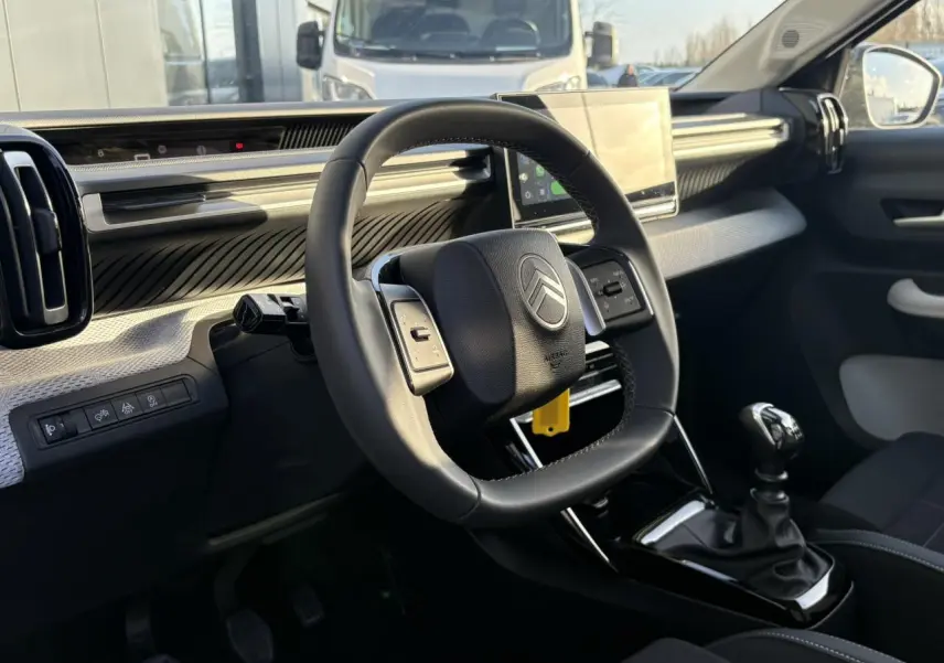 Vue intérieure côté conducteur du tableau de bord et volant de la Citroën C3 Turbo 100 Max avec écran tactile et boîte manuelle.
