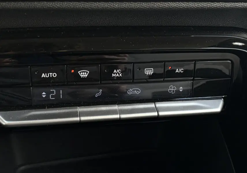 Gros plan sur la commande de climatisation automatique de la Citroën C3 Turbo 100 Max, finition noire brillante.