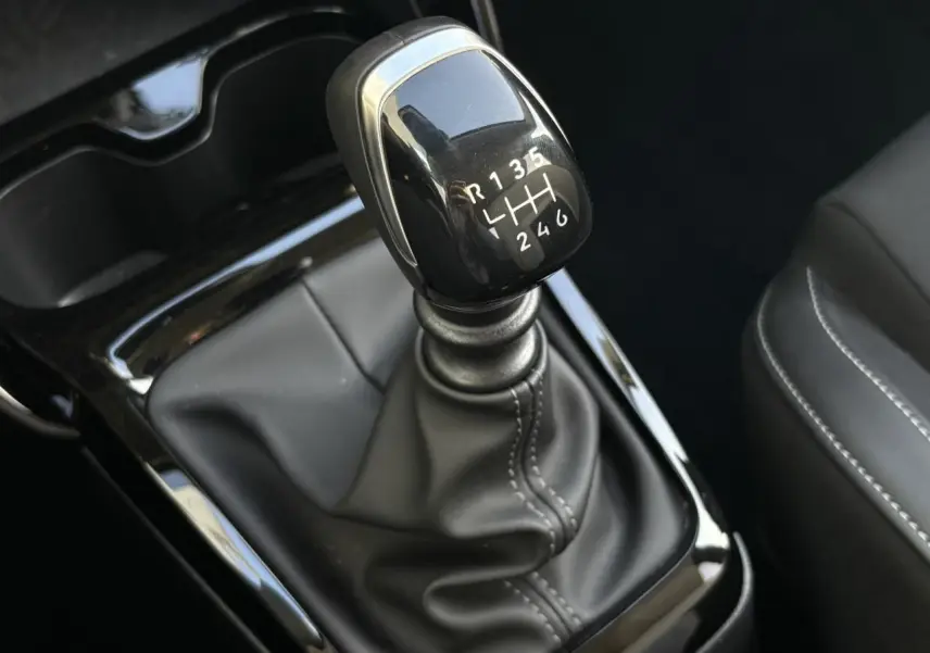 Gros plan sur le levier de vitesses manuel noir brillant de la Citroën C3 Turbo 100 Max, intérieur en cuir noir.