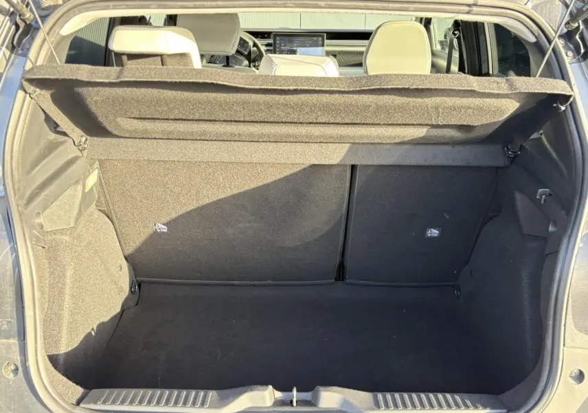 Vue du coffre ouvert d'une Citroën C3 2025 gris Mercury avec intérieur noir et sièges arrière visibles.