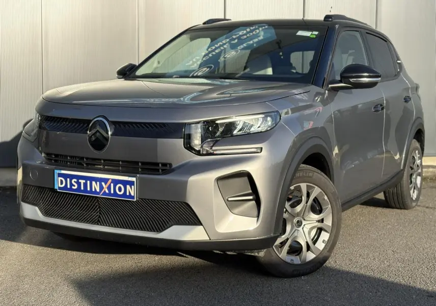 Vue 3/4 avant droite d'une Citroën C3 2025 gris Mercury avec toit noir et jantes alliage distinctives.