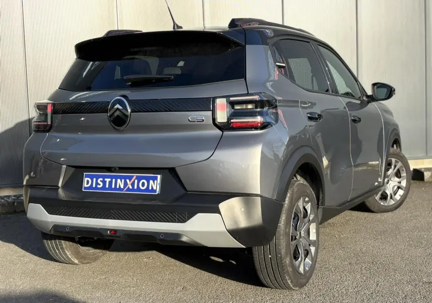 Vue 3/4 arrière droite d'une Citroën C3 2025 gris Mercury avec toit noir et feux arrière LED 3D.