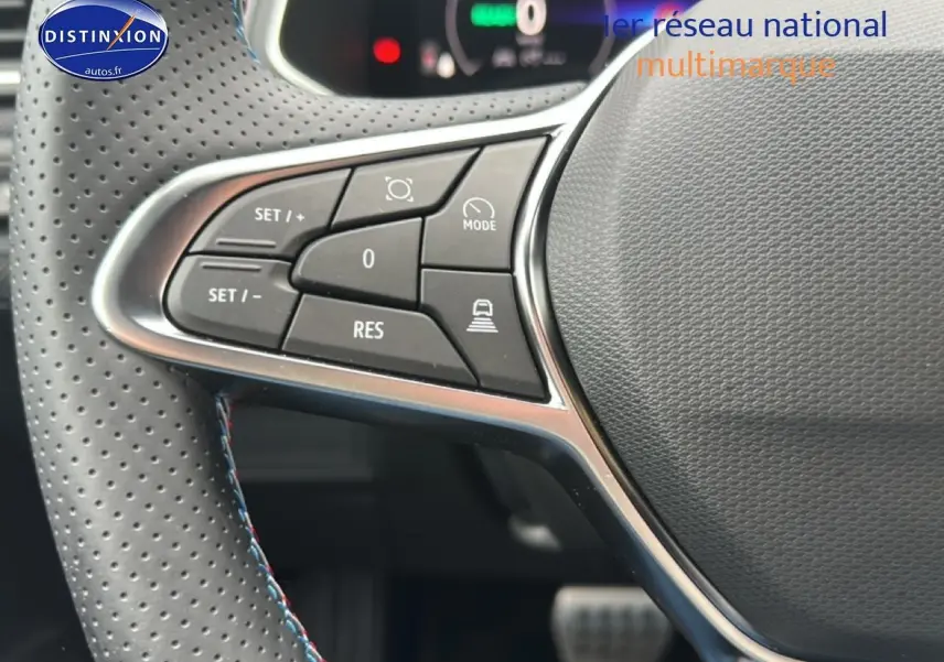 Gros plan sur les commandes à gauche du volant cuir perforé du Renault Captur 1.8 e-tech hybride 2025 esprit Alpine.