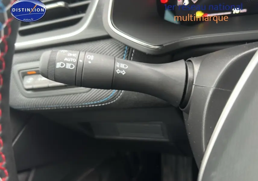 Détail du commodo d'éclairage à gauche du volant dans l'habitacle du Renault Captur bleu iron t/noir 2025 esprit alpine.
