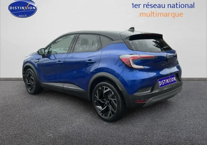 Renault Captur 2025 bleu iron et noir en 3/4 arrière droit, avec jantes alu noires et toit noir contrasté.