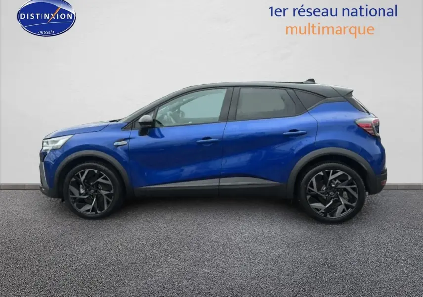 Profil droit du Renault Captur 2025 hybride bleu iron avec toit noir et jantes alu noires.