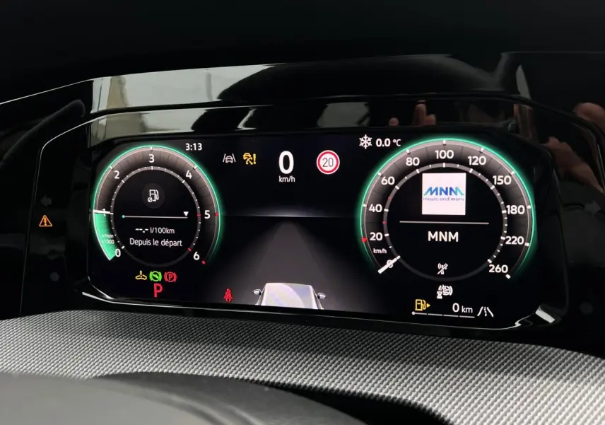 Tableau de bord numérique de Volkswagen Golf VIII noir, affichant vitesse, température et alertes au ralenti.