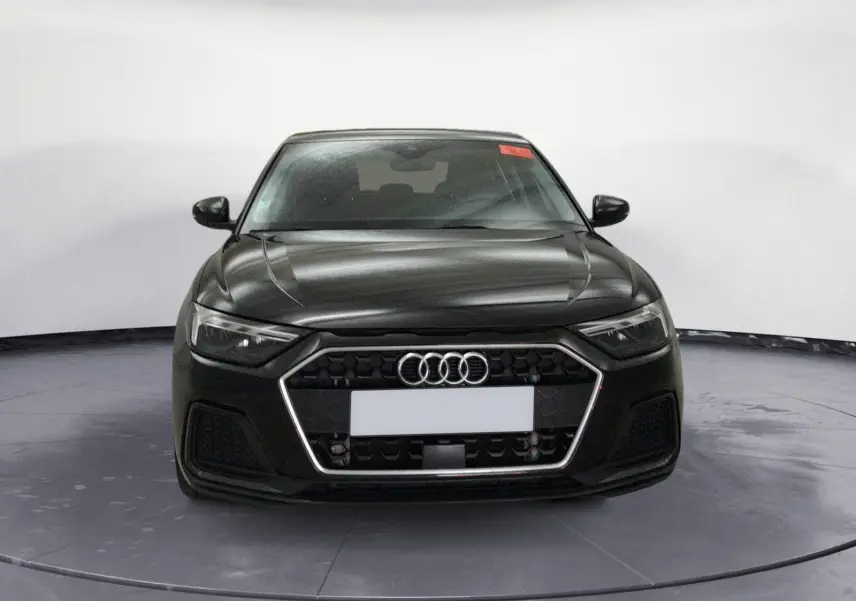 Audi A1 Sportback noir/gris vue 3/4 avant droit, avec jantes alliage et calandre hexagonale distinctive.