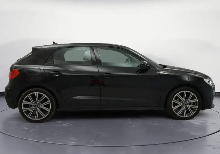 Audi A1 Sportback noir/gris vue 3/4 arrière droit, avec jantes alliage et feux arrière LED distinctifs.