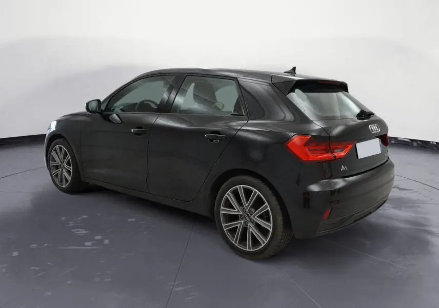 Vue intérieure côté conducteur de l'Audi A1 Sportback 2023 avec sièges sport noirs et volant cuir.