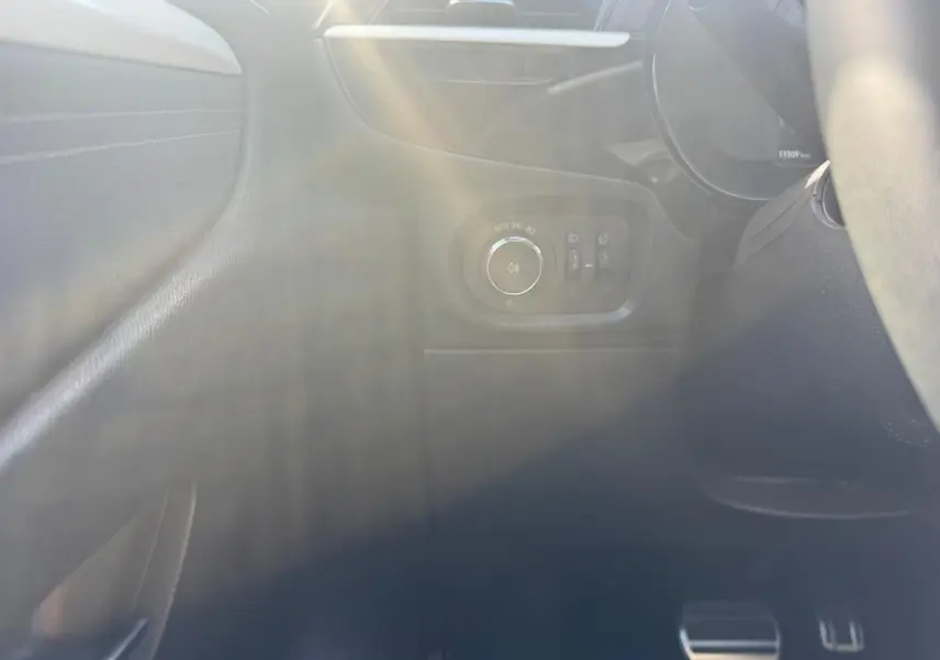 Détail du tableau de bord côté gauche de l’Opel Corsa noire 2025 avec commandes d’éclairage et pédales visibles.