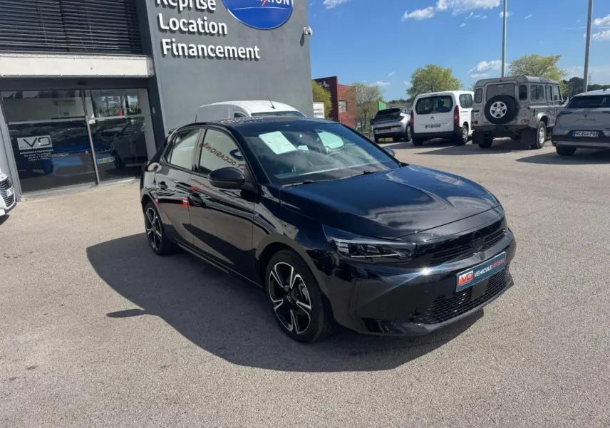 Opel Corsa noire vue 3/4 avant droit, jantes alliage 17 pouces, stationnée devant un concessionnaire.