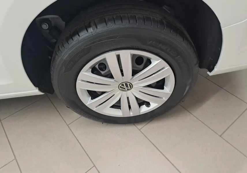 Gros plan sur la roue avant gauche du Volkswagen Caddy Cargo Maxi blanc candy, mettant en valeur la jante et le pneu.