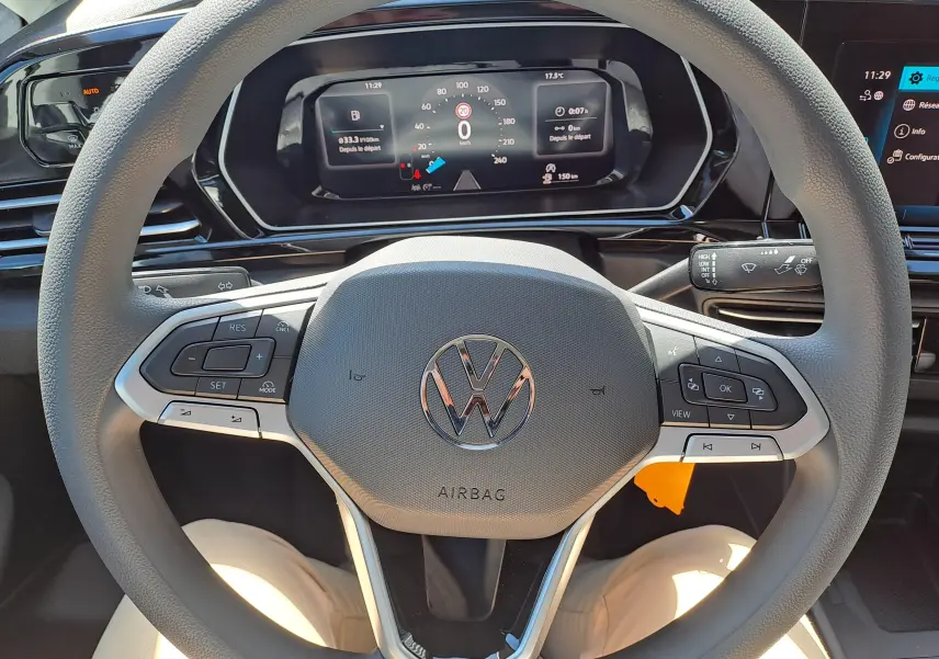 Vue intérieure centrée sur le volant gris du Volkswagen Caddy Cargo Maxi 2026 avec tableau de bord numérique allumé.