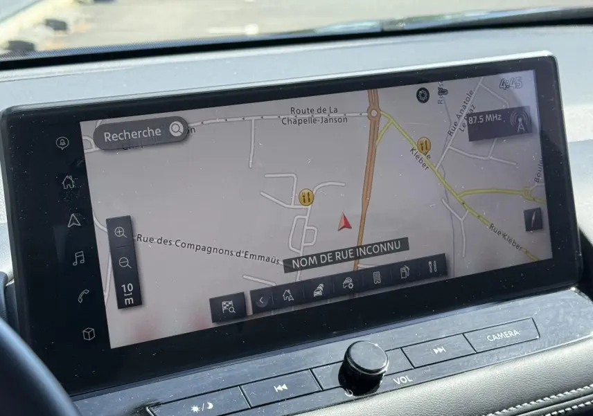 Vue intérieure du tableau de bord du Nissan X-TRAIL 2024, écran tactile affichant la navigation GPS en mode carte.
