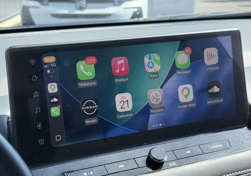 Écran tactile central du Nissan X-TRAIL 2024 affichant Apple CarPlay avec interface colorée et commandes intégrées.