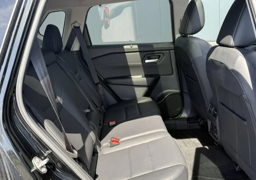 Vue intérieure côté gauche des sièges arrière en cuir noir du Nissan X-TRAIL 4X4 e-4orce 2024 avec ceinture de sécurité visible.