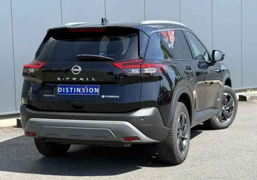 Vue 3/4 arrière droite du Nissan X-Trail 2024 noir intense avec badge e-4ORCE et toit panoramique visible.
