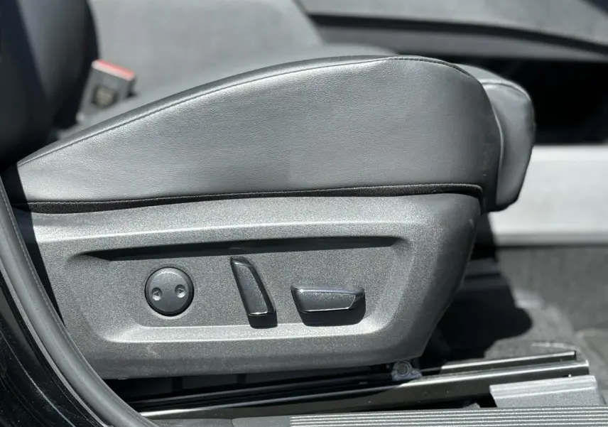 Gros plan sur les commandes électriques du siège avant gauche en cuir noir du Nissan X-TRAIL 2024.