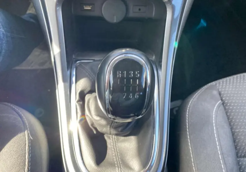 Gros plan sur le levier de vitesses manuel noir de l’Opel Astra Sports Tourer gris, avec indication des 6 rapports visibles.