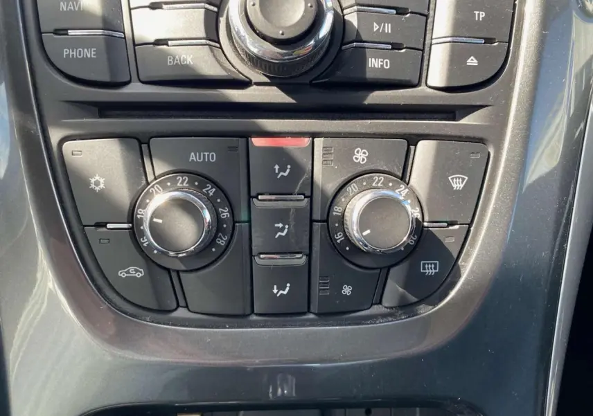 Vue rapprochée du tableau de commande de climatisation de l’Opel Astra Sports Tourer gris 2014 avec réglages manuels.