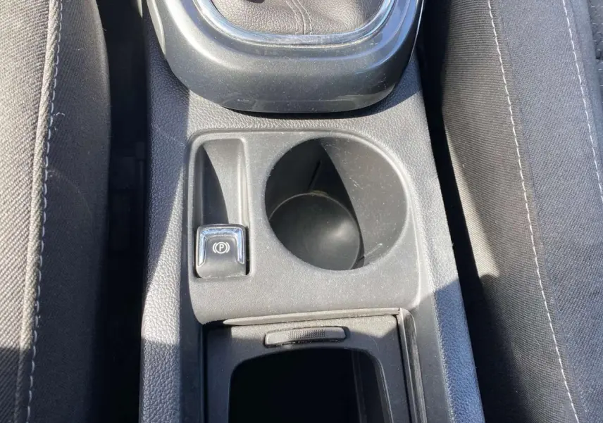 Gros plan sur la console centrale de l’Opel Astra Sports Tourer grise, montrant levier de vitesse, frein à main électrique et porte-gobelet.
