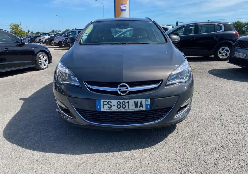 Vue de face d'une Opel Astra Sports Tourer gris métallisé, avec calandre et logo Opel bien visibles.