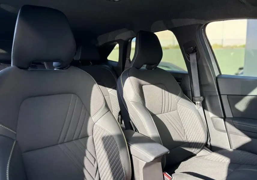 Vue intérieure des sièges avant en tissu gris avec accoudoir central dans une Renault Symbioz 2025.