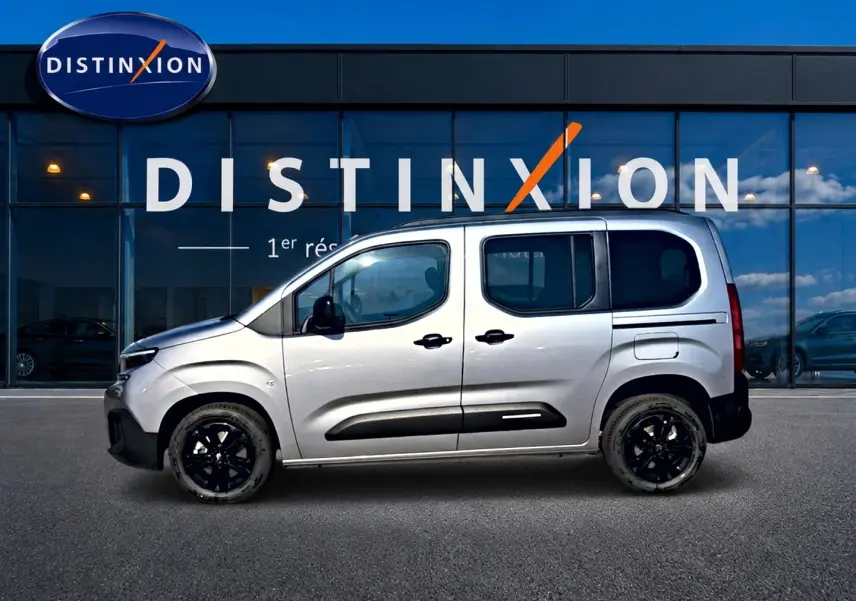 Vue latérale droite d'un Citroën Berlingo 2026 gris acier avec jantes noires et protections latérales noires.