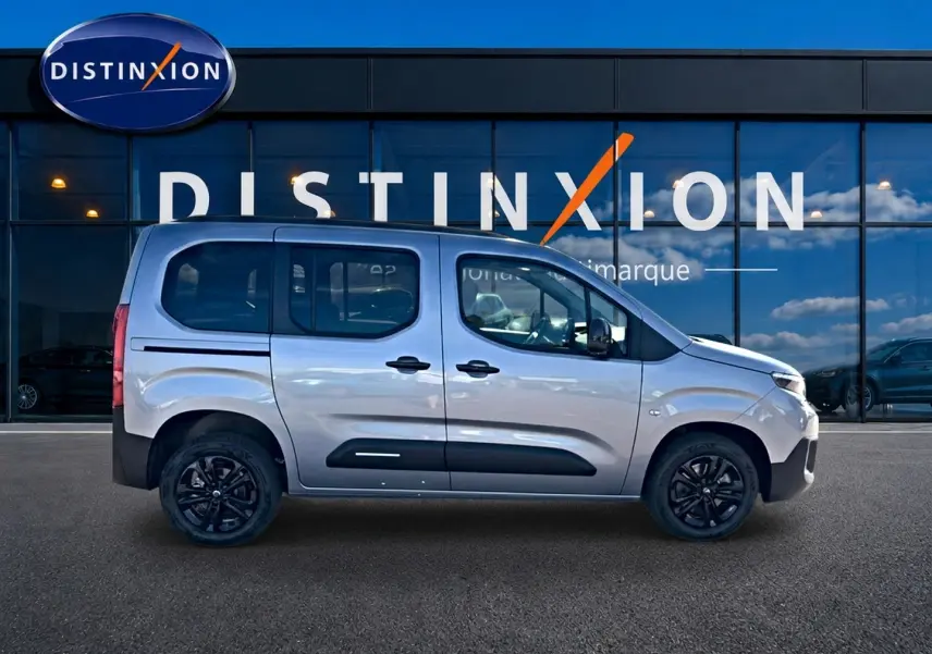 Vue de profil droit du Citroën Berlingo Steel Grey 2026 avec barres de toit et jantes noires.