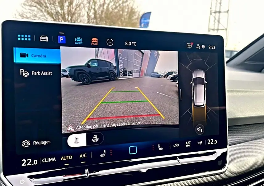 Écran tactile intérieur montrant la caméra de recul et l'assistance au stationnement d'une Volkswagen Golf noire.