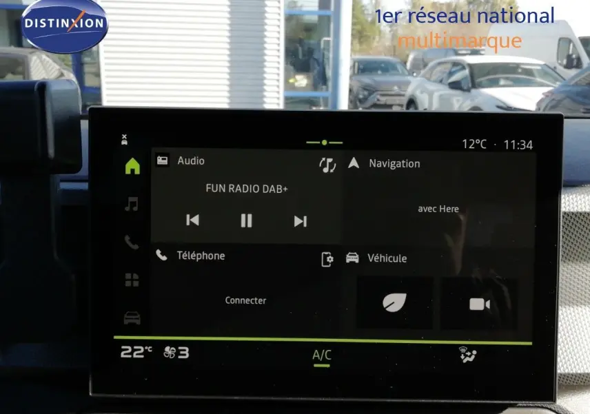 Écran tactile central du Dacia Duster gris schiste, affichant la radio et la navigation, vue intérieure frontale.