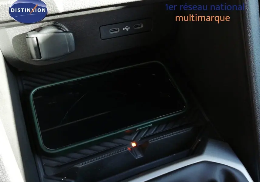 Gros plan sur la console centrale du Dacia Duster 2026, montrant un smartphone en charge sans fil et ports USB.