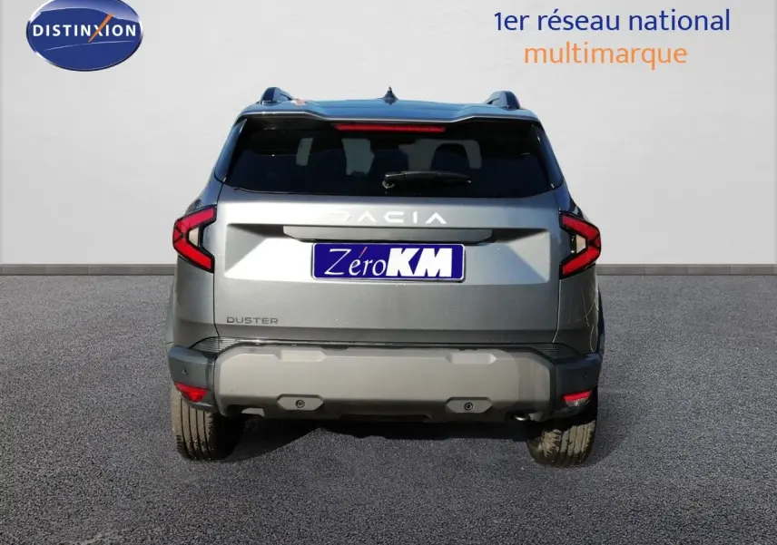 Vue arrière d'un Dacia Duster gris schiste métal 2026 avec feux LED et logo DACIA bien visible.