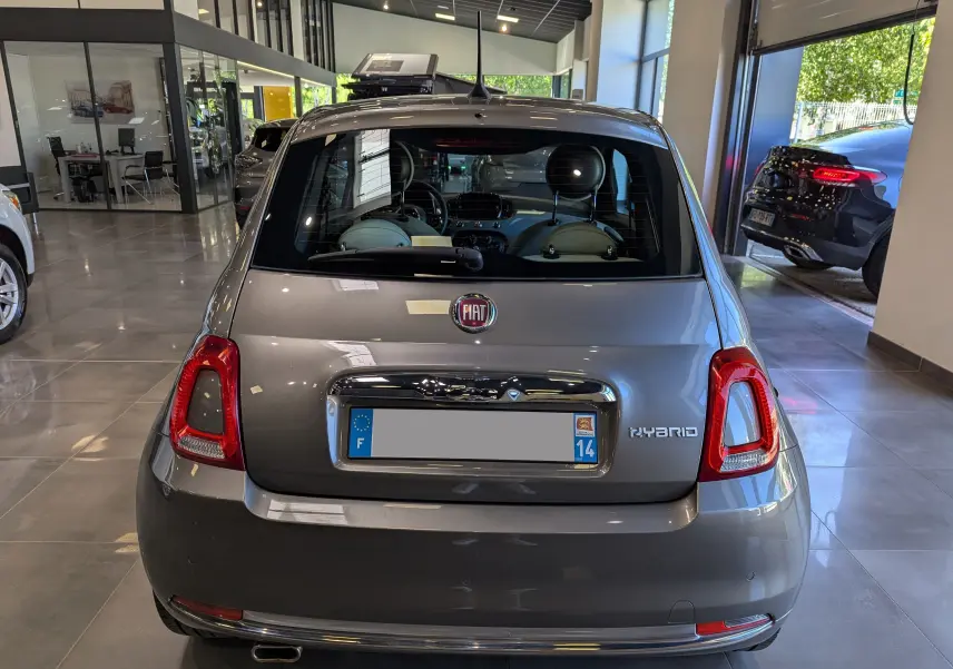 Vue arrière d'une FIAT 500 hybride Electroclash Grey 2021 dans un showroom lumineux avec détails chromés.