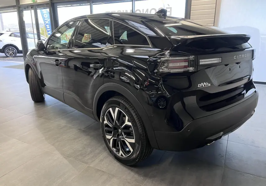 Vue 3/4 arrière droite d'une Citroën C4 noire métallisée avec jantes alliage et feux LED distinctifs.